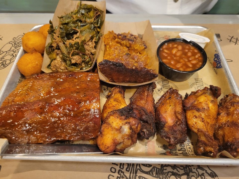 Plated barbecue and seafood dishes on a restaurant table.